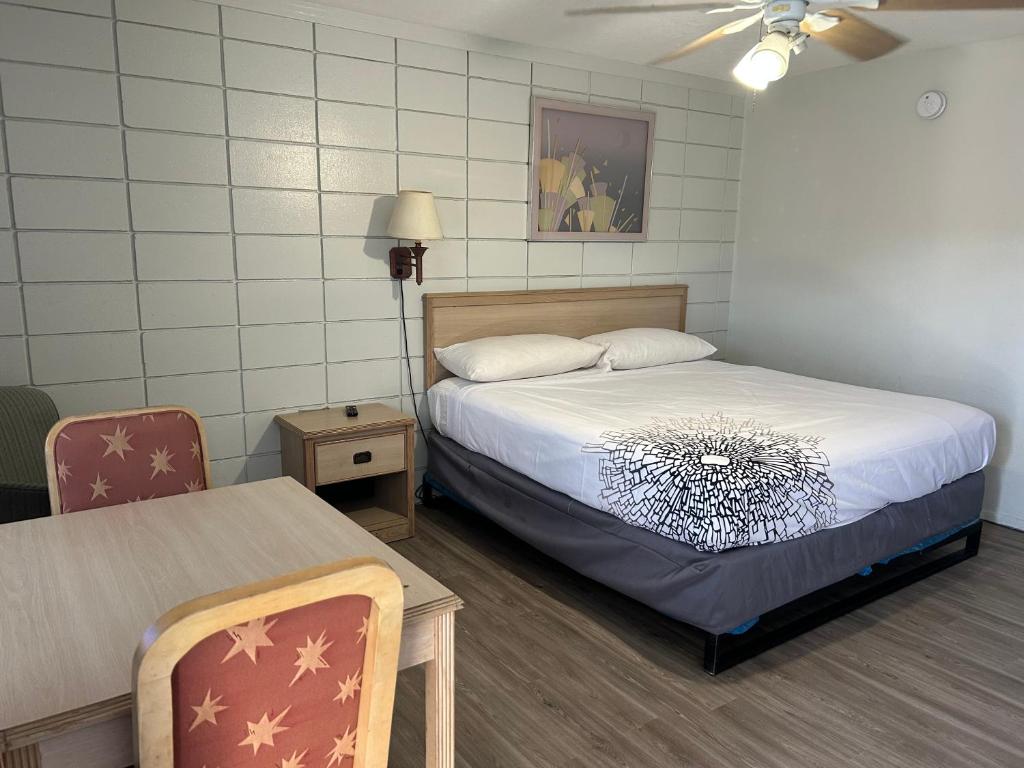 ein Schlafzimmer mit einem Bett, einem Tisch und einem Stuhl in der Unterkunft Candlelight Inn in St Petersburg