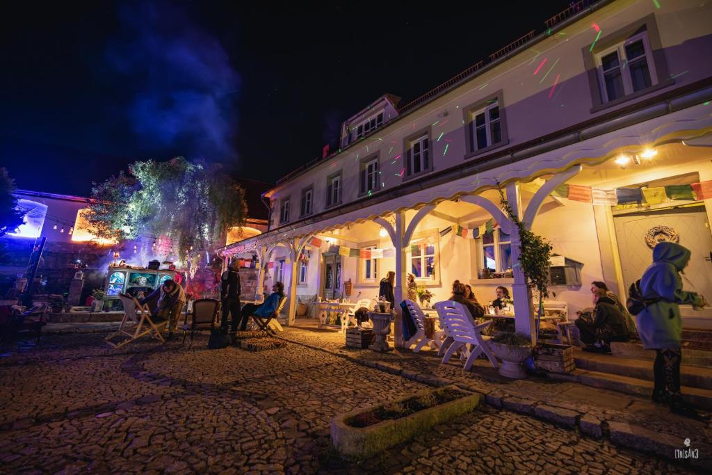 un groupe de personnes assises à l'extérieur d'un bâtiment la nuit dans l'établissement Turkusowa Wyspa, à Wleń