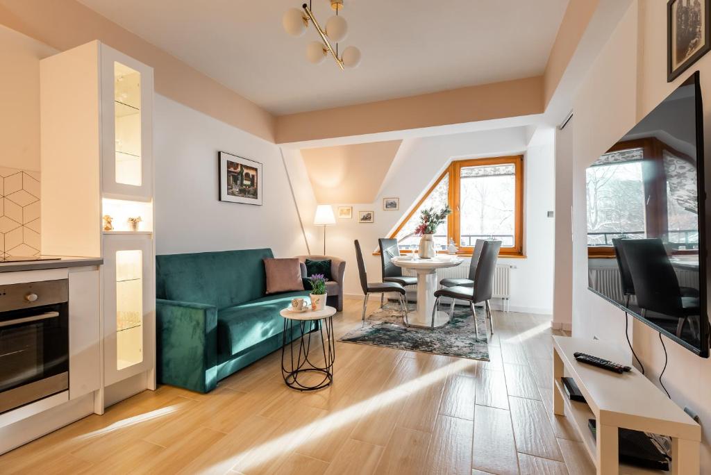 Televízia a/alebo spoločenská miestnosť v ubytovaní Apartamenty Orkana Centrum Zakopane