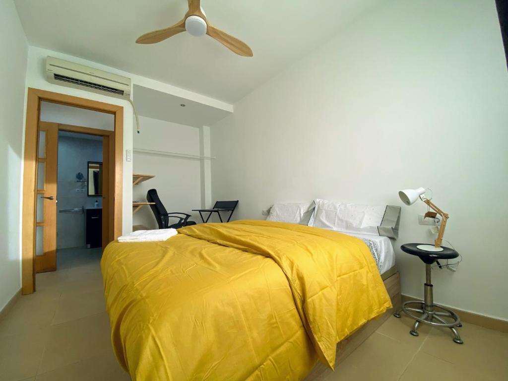 1 dormitorio con 1 cama con manta amarilla en Mini Terraza Relajante Galvani, en Terrassa