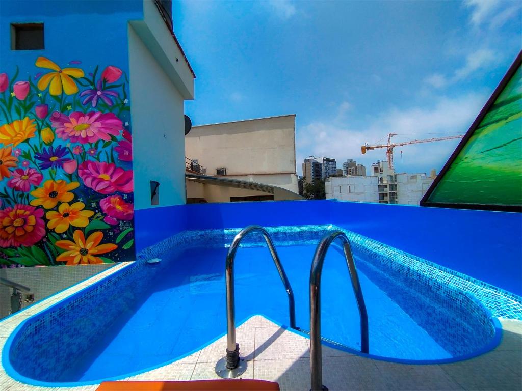 una piscina con un mural en el lateral de un edificio en Casa Fanning Hotel, en Lima