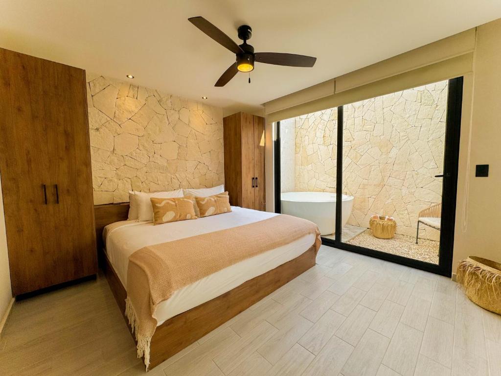 Un dormitorio con una cama y un ventilador de techo. en TÚ REFUGIO EXCLUSIVO EN TULUM, DK JADE 3 By SANDY POWERFUL, en Tulum