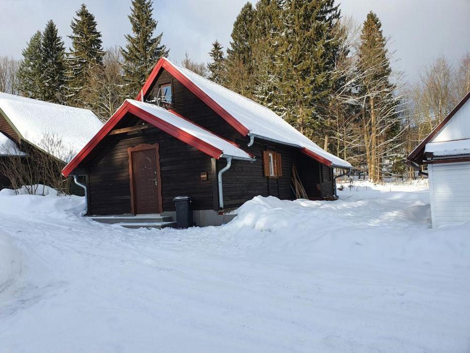 una pequeña casa de madera con nieve en el techo en Domek Biała Dolina, en Szklarska Poręba