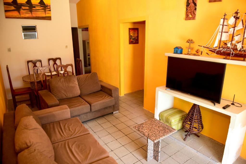 a living room with a couch and a flat screen tv at Excelente casa c lazer prox a praia Tamandare PE in Tamandaré