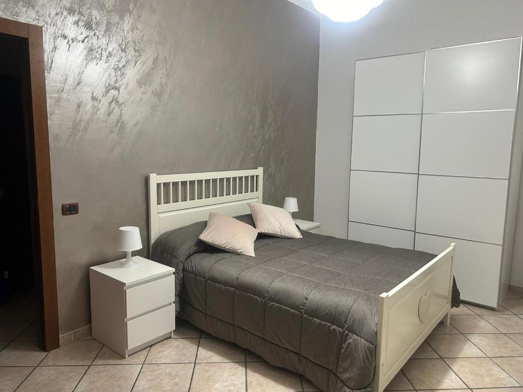 a bedroom with a bed and a white wall at alloggio di ketty in Naples