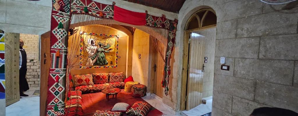 ein Wohnzimmer mit einem Sofa und einem Gemälde an der Wand in der Unterkunft Queen House in Assuan
