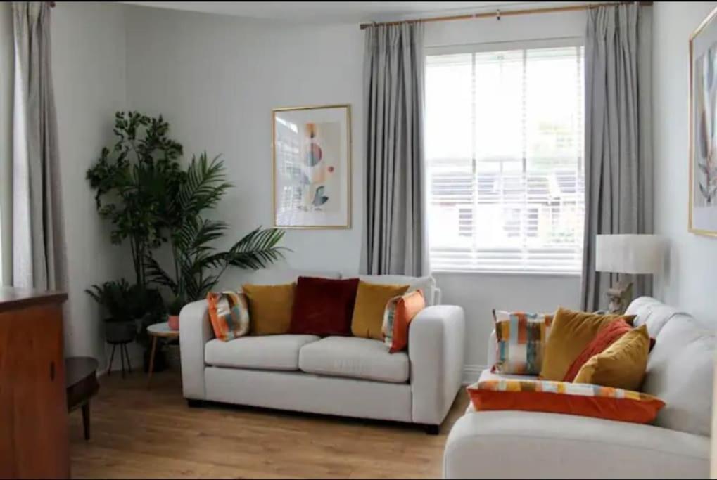 a living room with a white couch and a window at Clement House, York, Free EV and parking in York