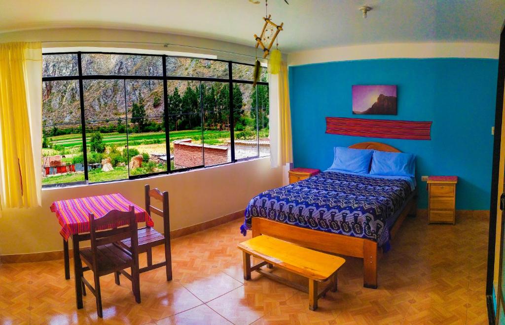 a bedroom with a bed and a large window at Casa Samay Mountain View in Ollantaytambo