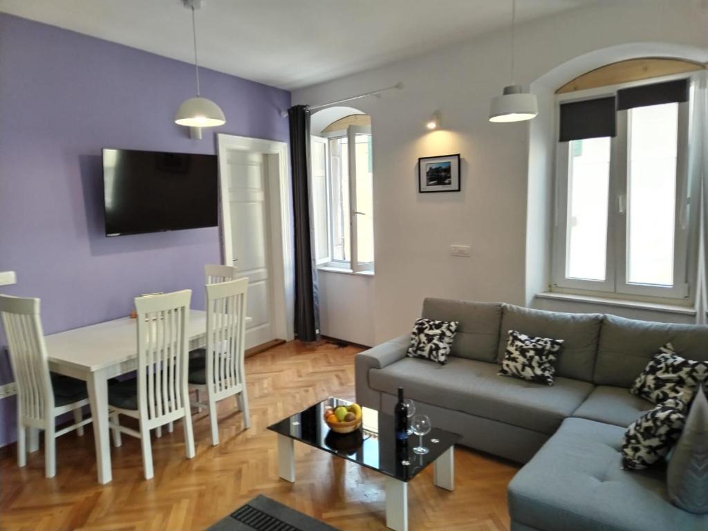 a living room with a couch and a table at Garden Apartment in Split