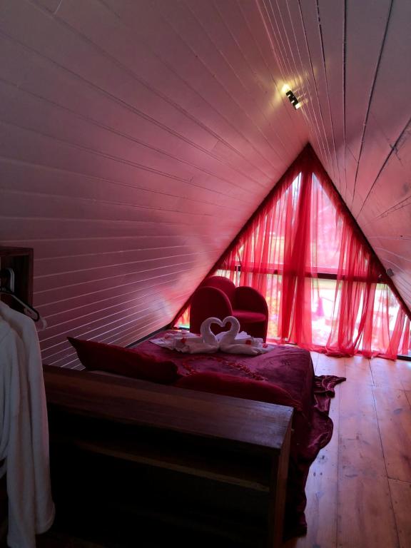um quarto com uma cama numa tenda vermelha em Chalé do amor, sítio pousada vô Maneca em Timbó