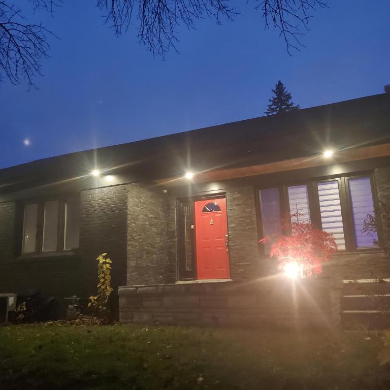 uma casa com uma porta vermelha à noite em beautiful 2 level bungalow in a posh neighborhood. em Toronto