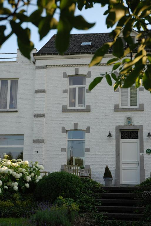 a white brick house with a white door at Ô lit de l'Ourthe in Hotton