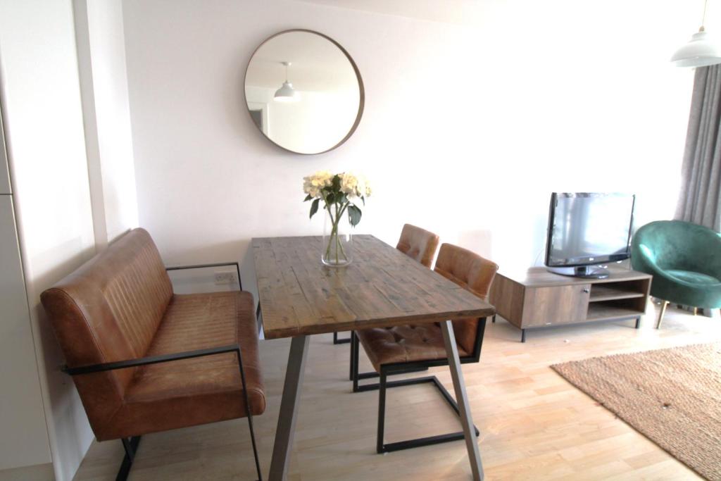 a dining room with a table and chairs and a mirror at The Elm @ Short Stays in Basingstoke