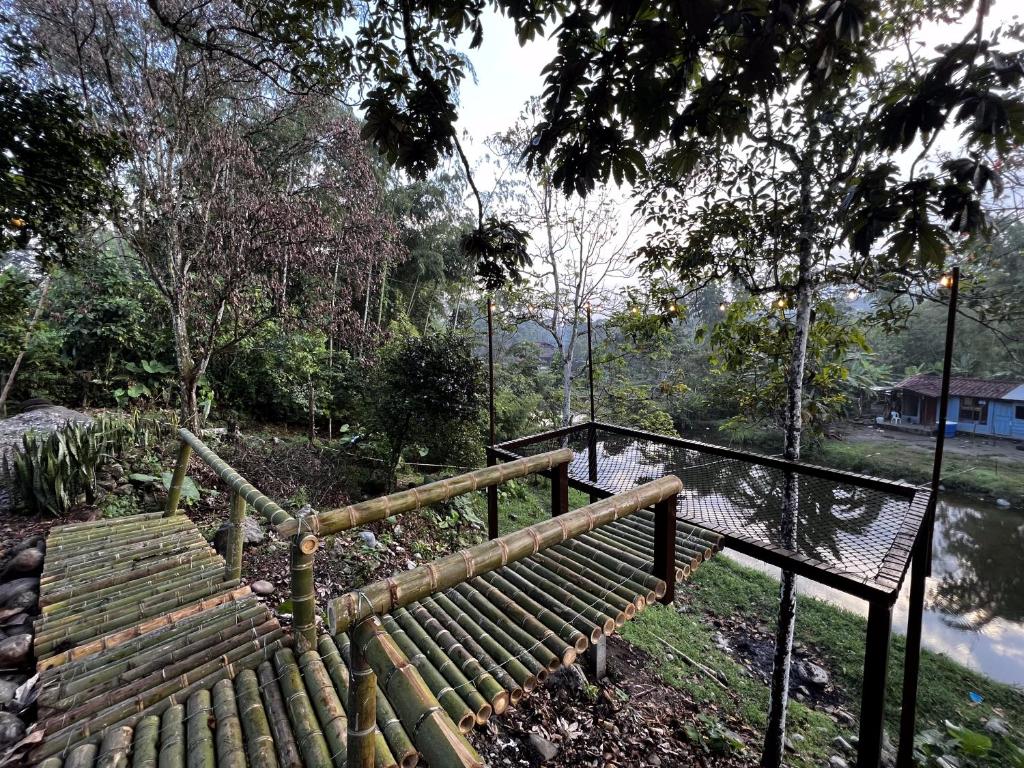 a wooden bench in a park next to a bridge at Finca Mi Carmencita in Mocoa