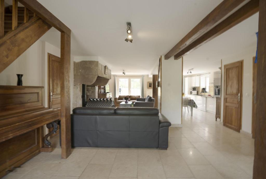 ein Wohnzimmer mit einem Sofa und einer Küche in der Unterkunft Retrouvailles Vosges comtoises msp Raphi et Gabi SPA in Mailleroncourt-Saint-Pancras