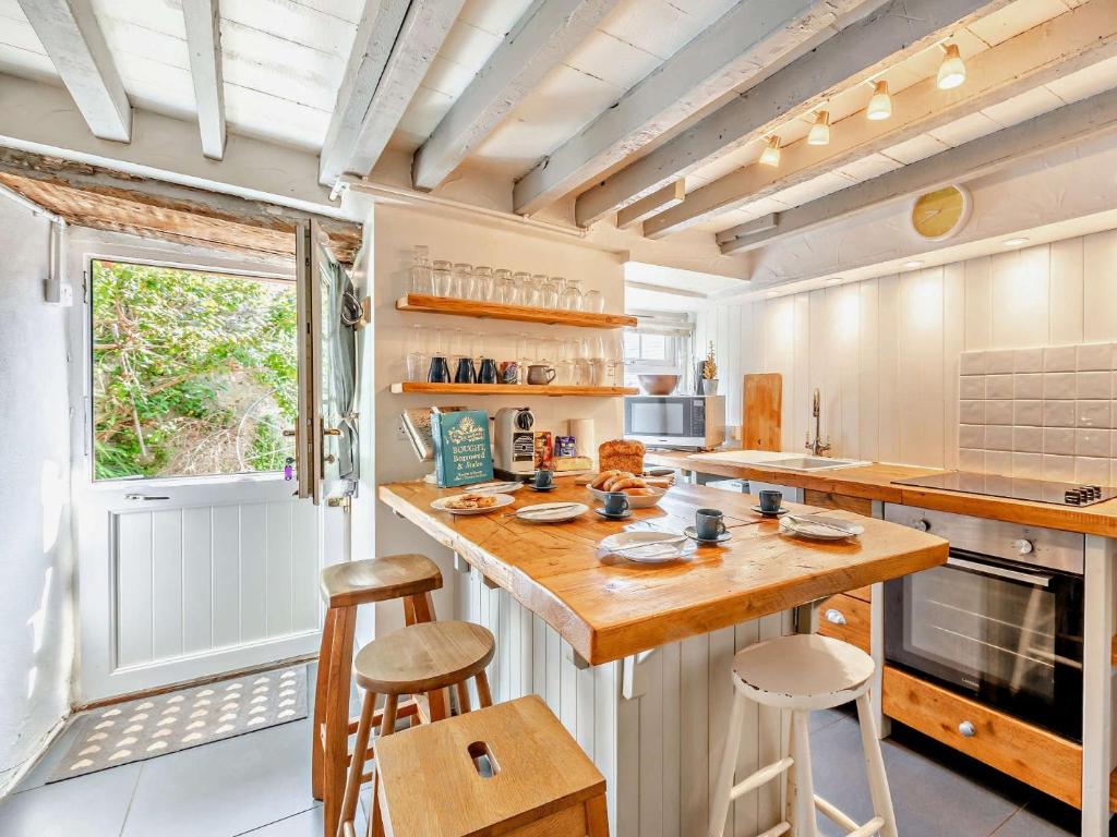 a kitchen with a large wooden counter and stools at 2 bed in Brixham BX020 in Brixham