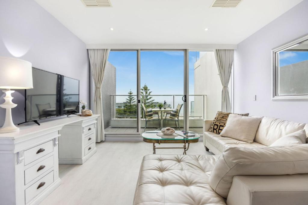 a living room with a white couch and a large window at Belle Escapes - Bay View Lookout With Sea Views in Glenelg