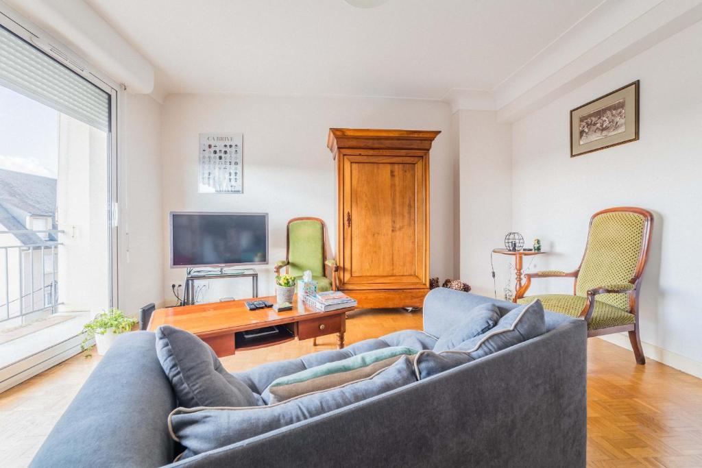 un salon avec un canapé et une télévision dans l'établissement Le Refuge de l'Écrivain - 2 Chambres, à Brive-la-Gaillarde