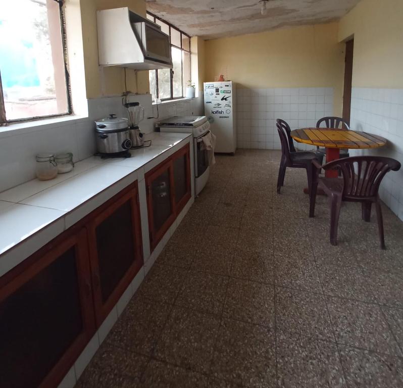 eine Küche mit einem Tisch, Stühlen und einem Tisch in der Unterkunft Casa hospedaje cora in Barrio Bellavista