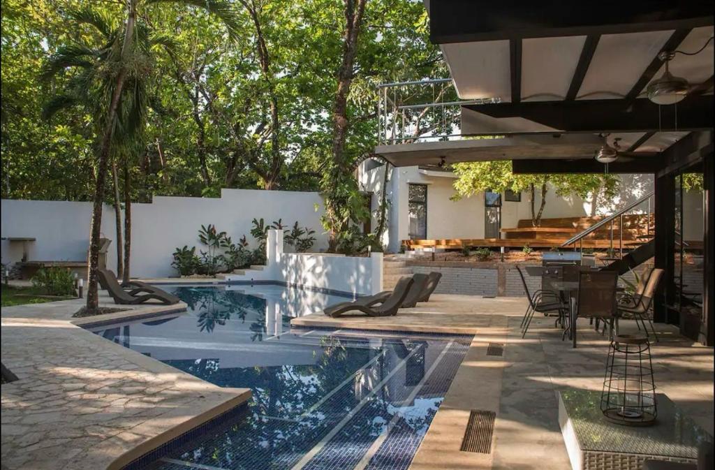 una piscina en un patio trasero con mesa y sillas en Casa Guarumo - An oasis in Playa Carrillo., en Carrillo