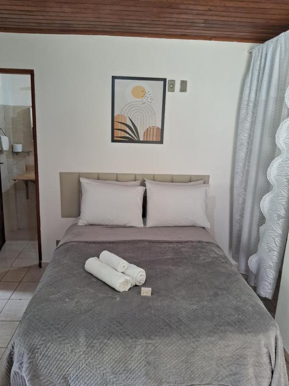 a bed with two white towels on top of it at Chalé do riacho 2 in Penedo