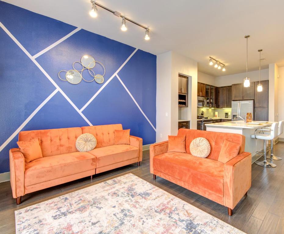 a living room with two orange couches and a blue wall at The Tangerine Dream in Houston