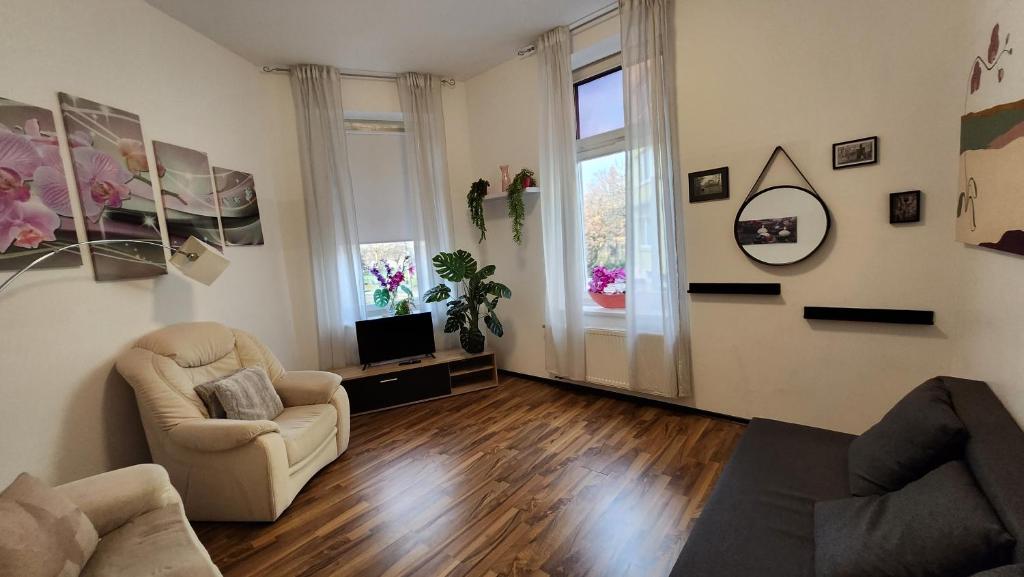 een woonkamer met 2 stoelen en een televisie bij ELENA flat Orchidee Duisburg Zentrum in Duisburg