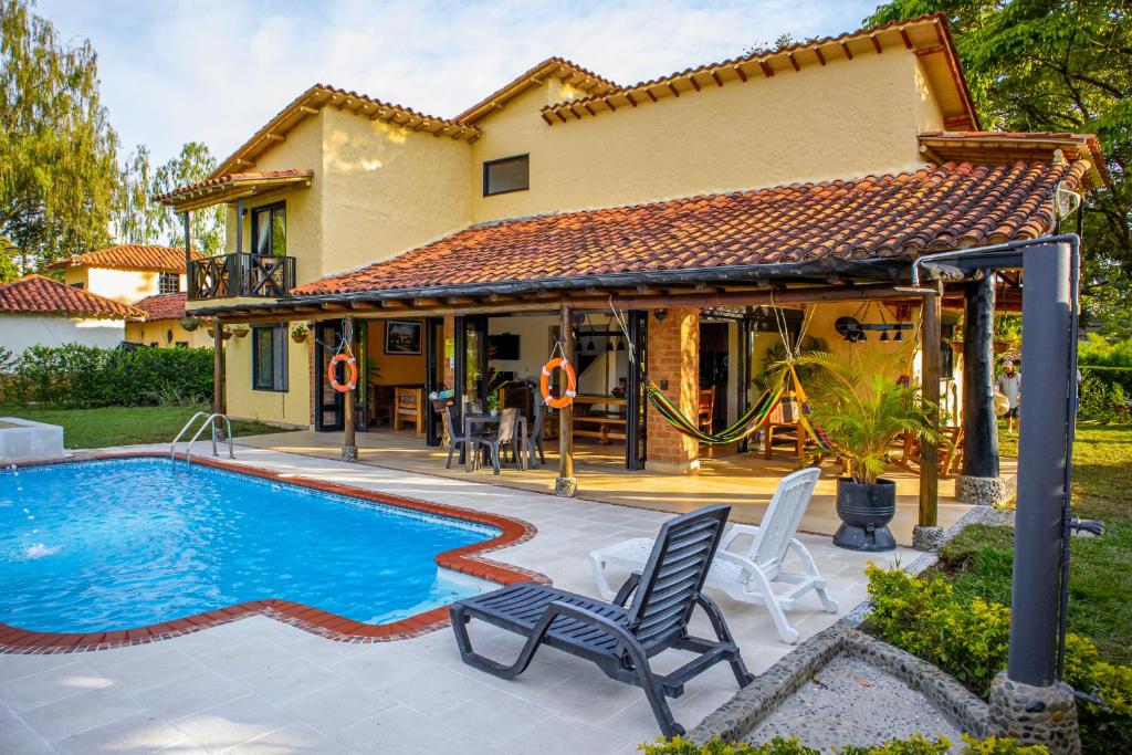 una casa con piscina di fronte a una casa di Villas Panaca Portal 1 a Quimbaya