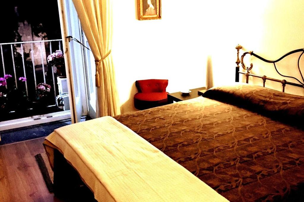 - une chambre avec un lit, une fenêtre et une chaise dans l'établissement MARIA ROSARIA A SANTA CHIARA, à Naples