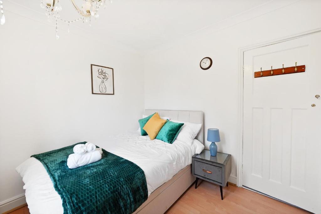 ein Schlafzimmer mit einem Bett mit einer grünen Decke in der Unterkunft Dunstable 3 bedroom house with Free Parking in Dunstable