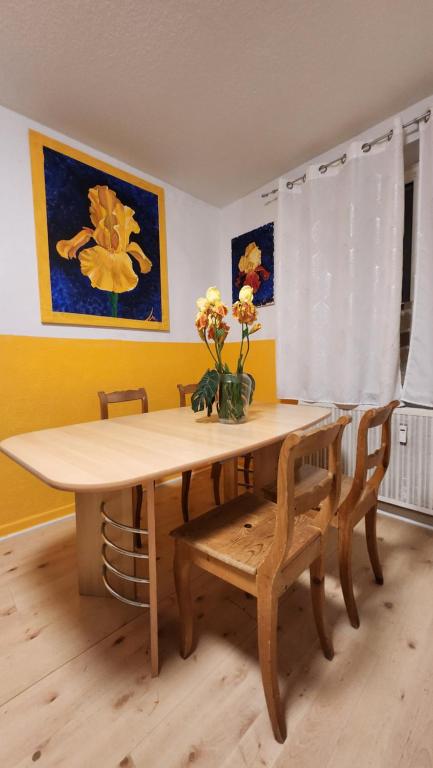 - une table à manger avec un vase de fleurs dans l'établissement ELENA flat IRIS, Oberhausen Zentrum CentrO Westfield, à Oberhausen