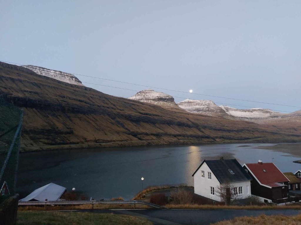 una casa en medio de un cuerpo de agua en Fjord Guesthouse en Funningsfjørður