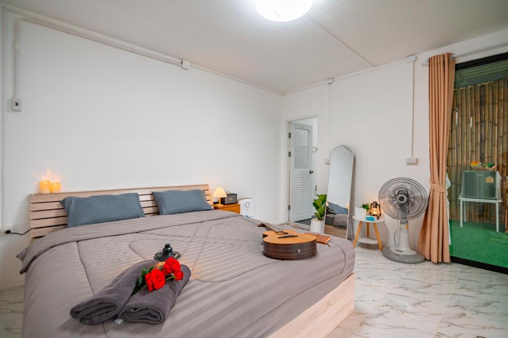 1 dormitorio con 1 cama grande y ventilador en ม่านเขาโฮมสเตย์Mankhao Homestay บ้านกระจก, 