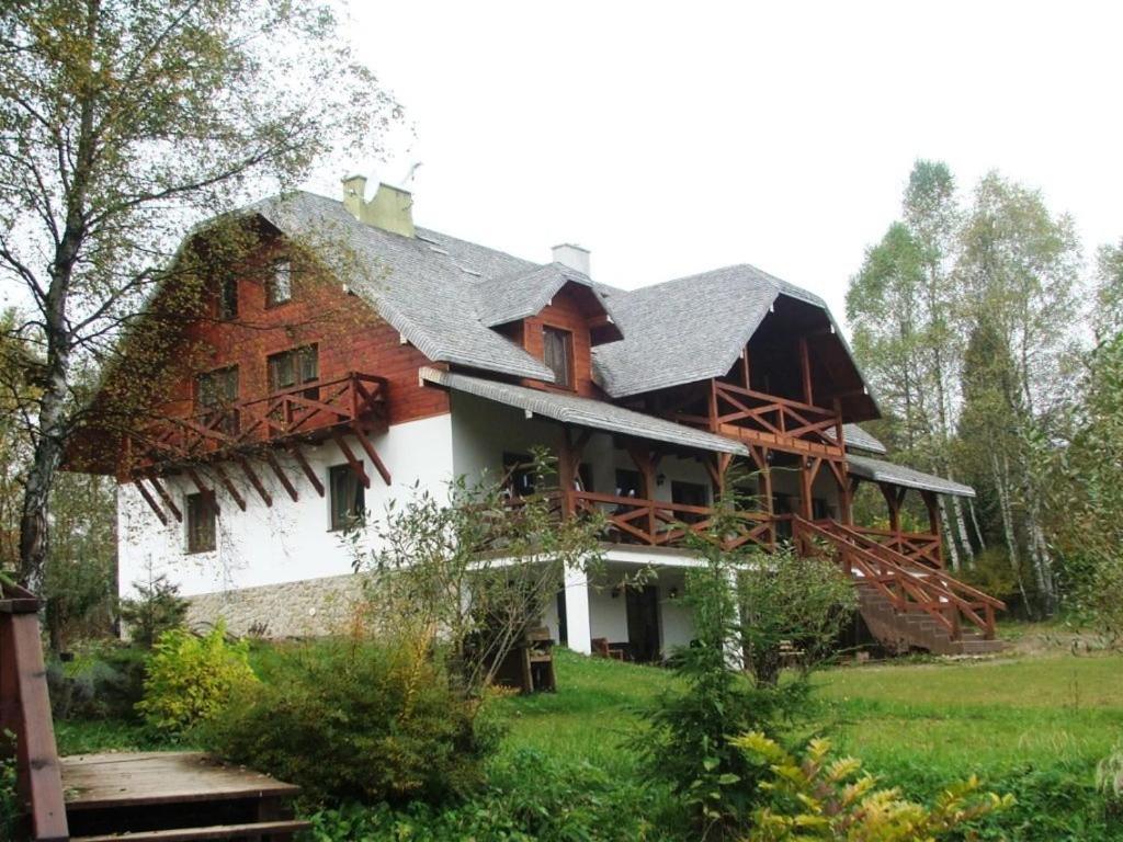 a large house with a thatched roof at Siedlisko Brzeziniak in Cisna