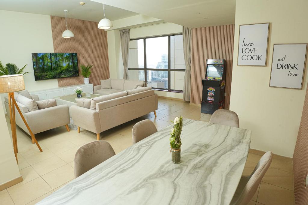 Pure Sand - Luxury Hostel JBR Dubai في دبي: غرفة معيشة مع طاولة وكراسي وأريكة