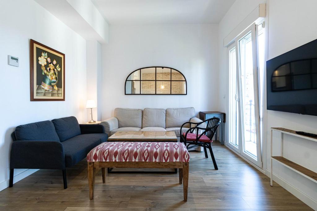 a living room with a couch and a table at Sepúlveda, tranquilo y con piscina by OUTIN in Seville