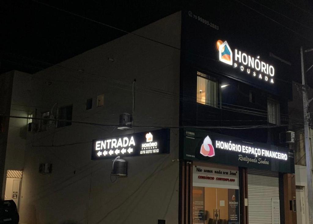 un magasin avec des panneaux sur le côté d'un bâtiment dans l'établissement Honório pousada - Tucano BA, à Tucano