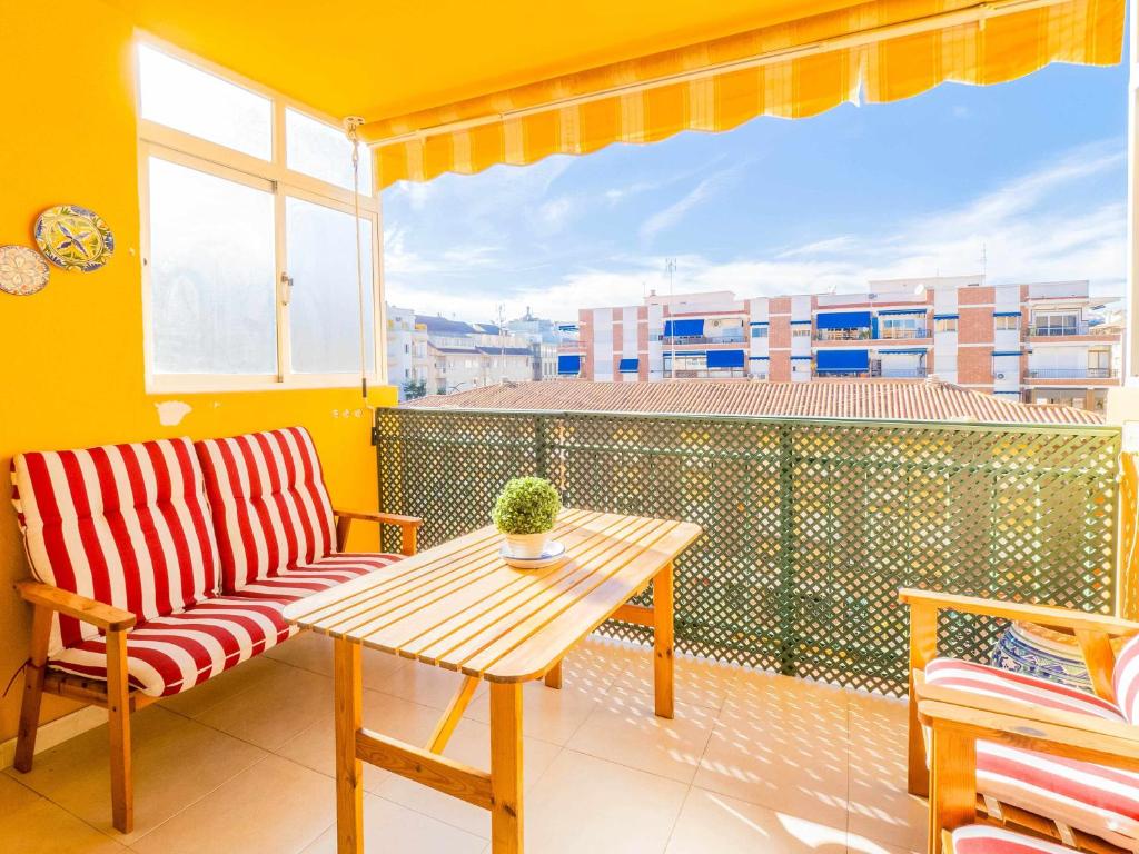 a balcony with a table and a chair and a window at Céntrico apartamento con terraza en la playa in Rincón de la Victoria