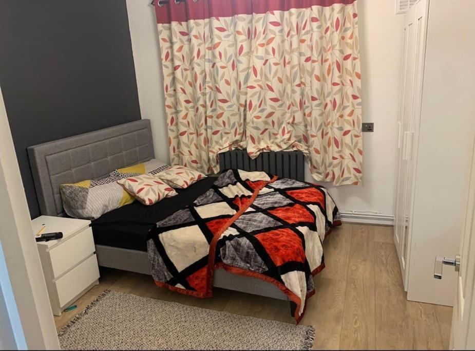 Habitación pequeña con cama y cortina en Cozy flat next to southmead hospital and gloucester road, en Bristol