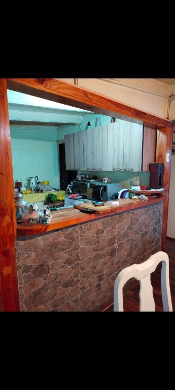 une cuisine avec une chaise blanche devant un comptoir dans l'établissement Cabañas y Hospedaje Claudia, à Temuco