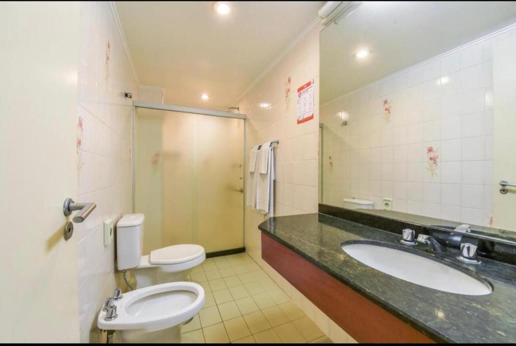 a bathroom with two sinks and two toilets at Apart hotel - apartments in Campinas