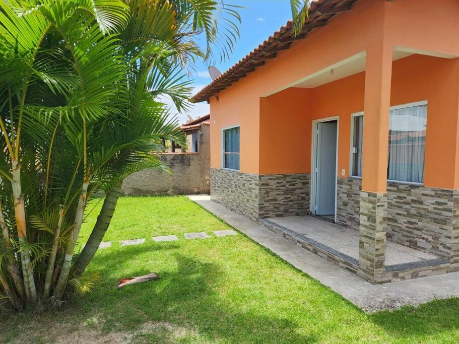 ein Haus mit einer Palme davor in der Unterkunft Casa em condomínio em Araruama in Araruama