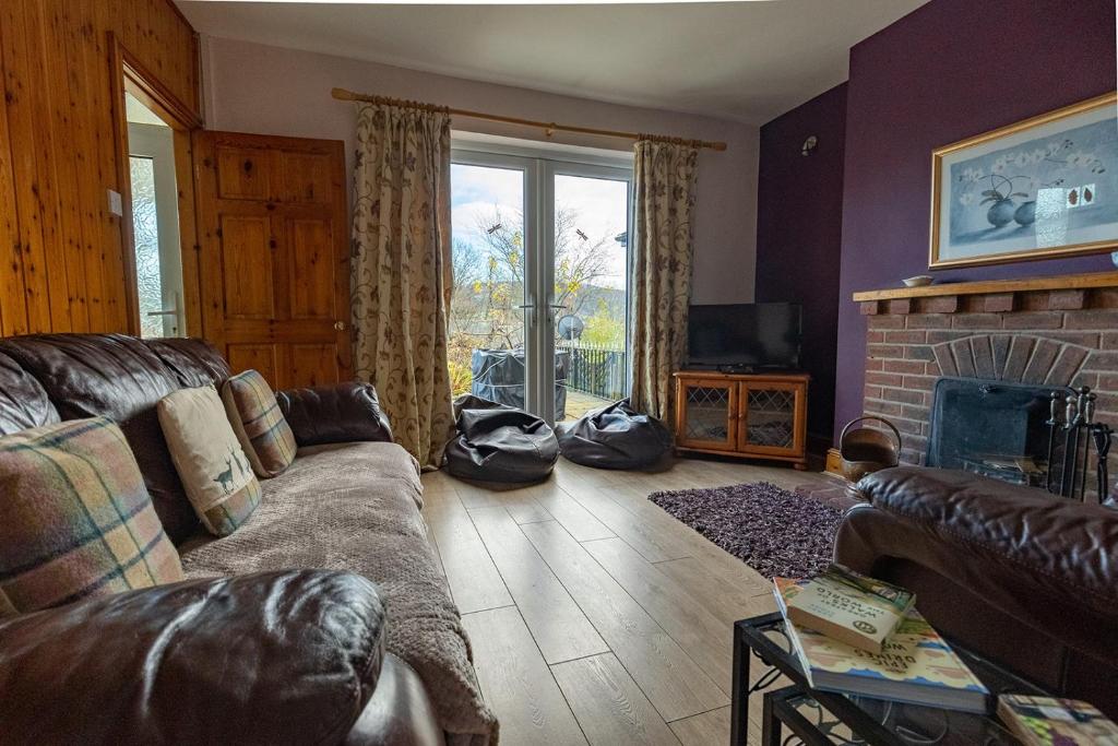 a living room with a couch and a fireplace at HILLSIDE COTTAGE - 3 bed property in North Wales opposite Adventure Park Snowdonia in Dolgarrog