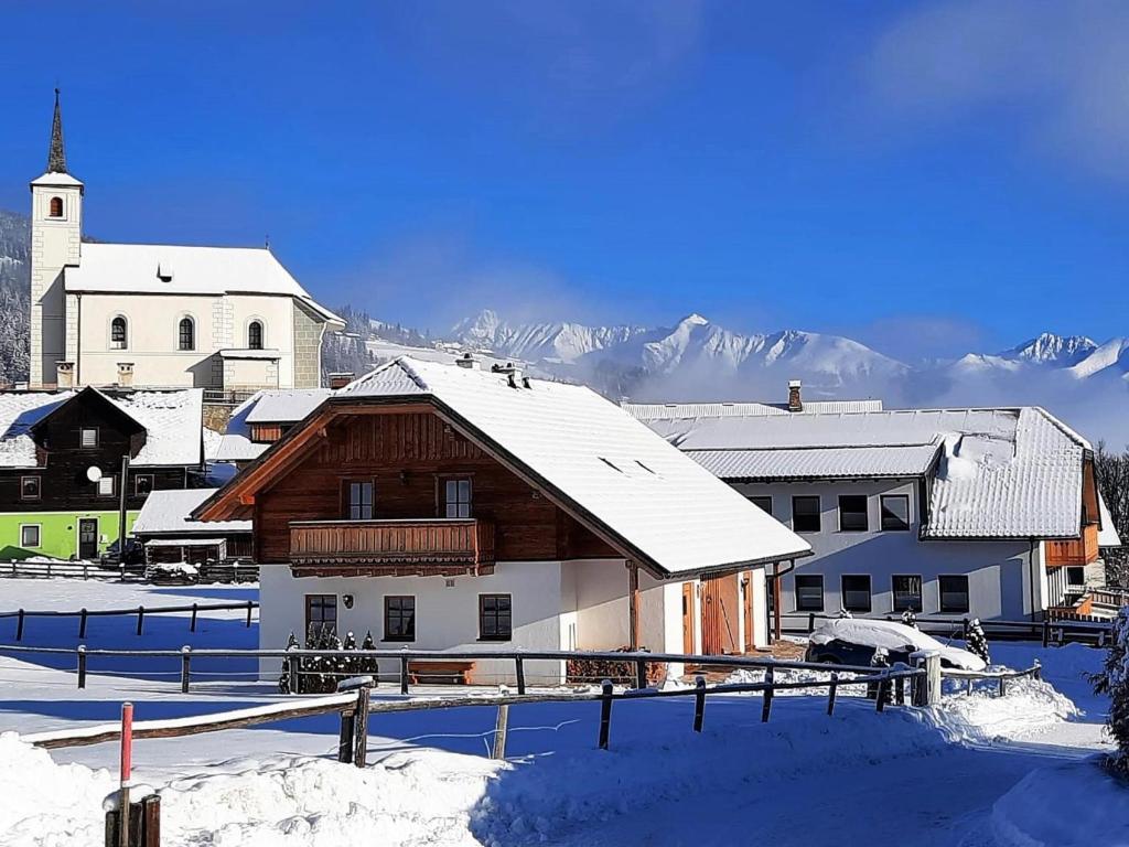 budynek w śniegu z górą w tle w obiekcie Wolfgangchalet A w mieście Mauterndorf