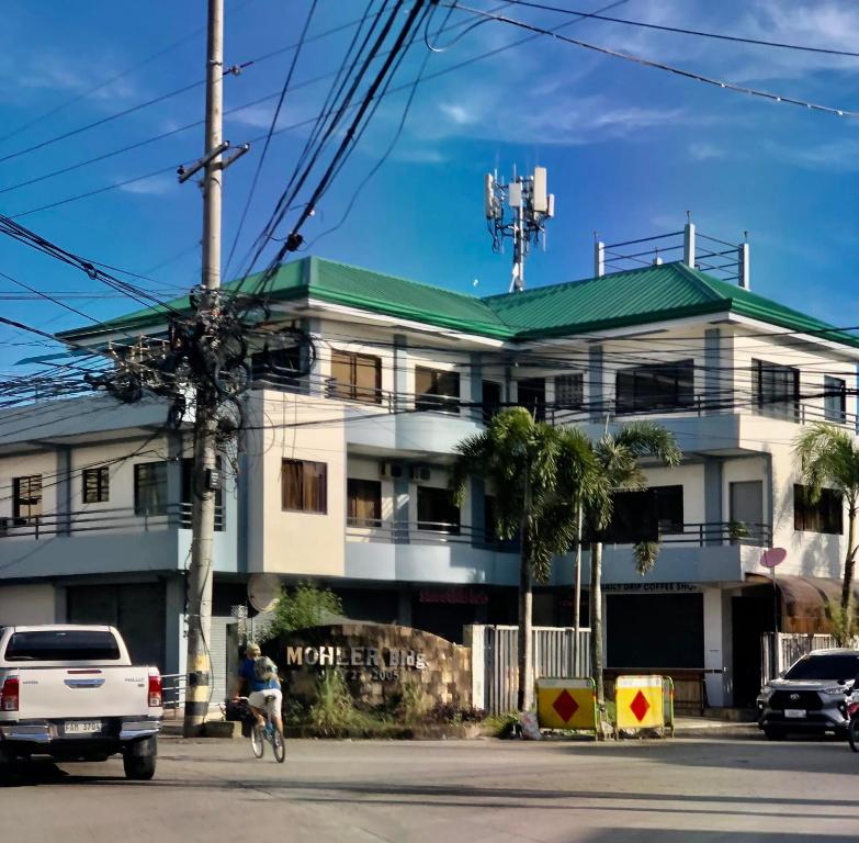 un edificio blanco con techo verde en una calle en Cranberry's Place-near CONVENTION center en Iloilo