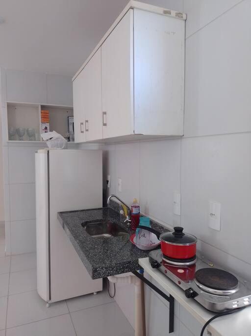 a white kitchen with a sink and a stove at Campina Residence in Campina Grande