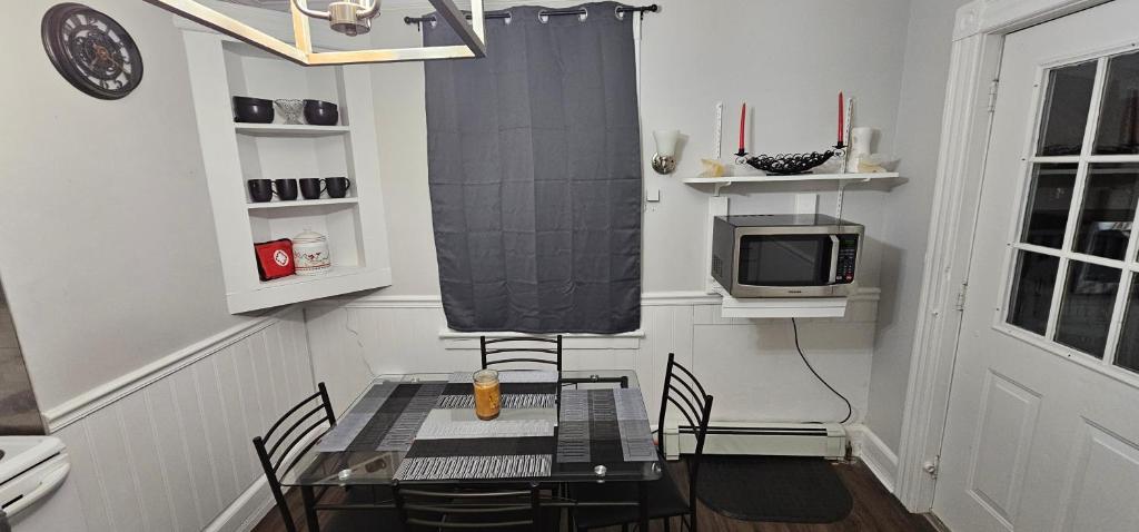 uma sala de jantar com uma mesa com cadeiras e uma televisão em Private Apt in Middletown-Wesleyan em Middletown