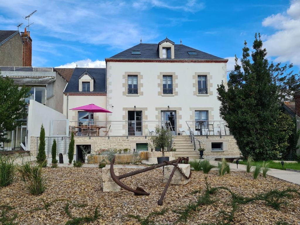 una gran casa blanca con un parque infantil delante de ella en Guestroom Briare, 1 pièce, 2 personnes - FR-1-590-368, en Briare