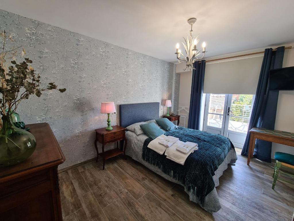 a bedroom with a bed with a blue blanket and a window at Guestroom Briare, 1 pièce, 2 personnes - FR-1-590-369 in Briare