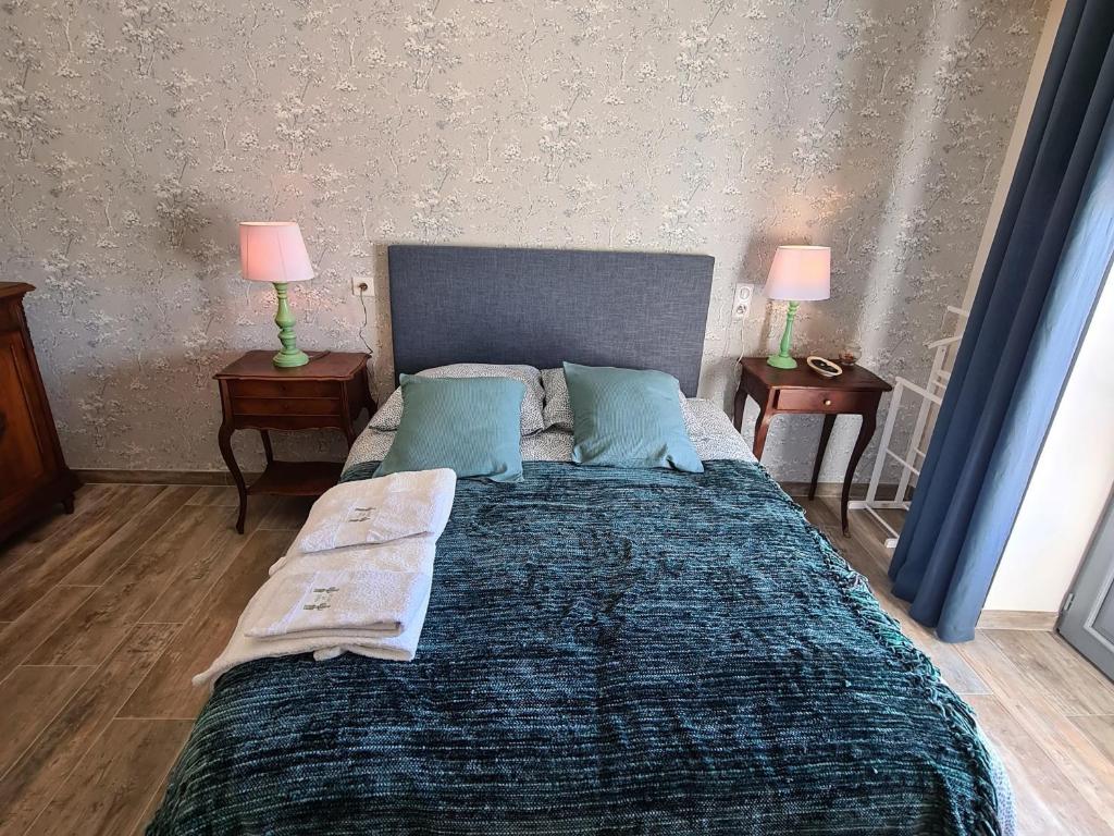 a bedroom with a large bed with two lamps on tables at Guestroom Briare, 1 pièce, 2 personnes - FR-1-590-369 in Briare